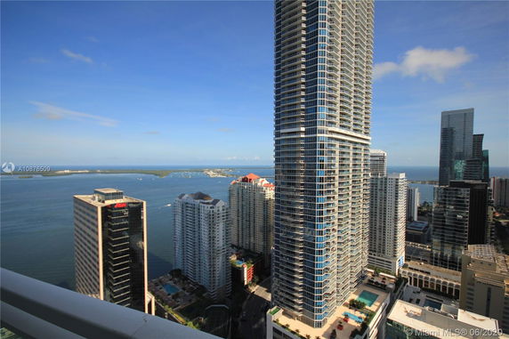 Panoramic view of cityscape and ocean with multiple high-rise buildings.