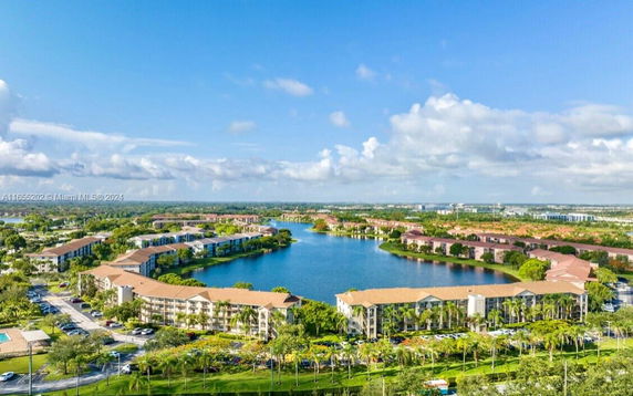 Aerial view of a residential area with a lake surrounded by multi-story buildings.