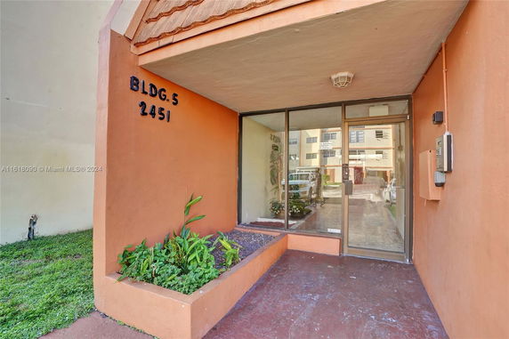 Front view of a building entrance with glass doors and an awning.
