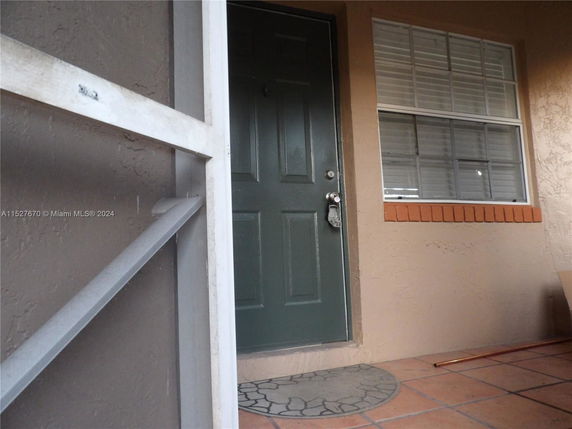 Front view of a house entrance with a dark green door and a window.