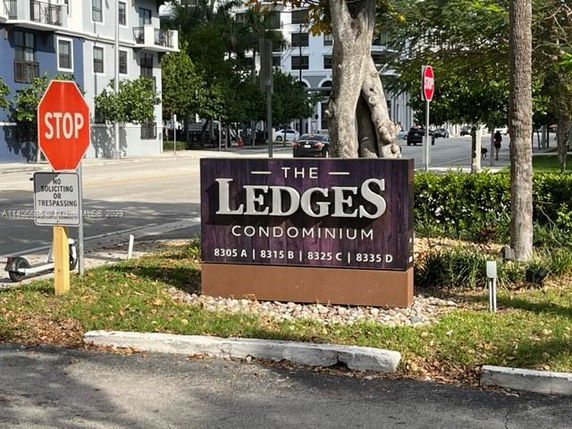 Front view of a condominium building with a sign 'The Ledges Condominium' indicating various building numbers.