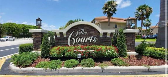 Entrance sign of a residential community named 'The Courts'.