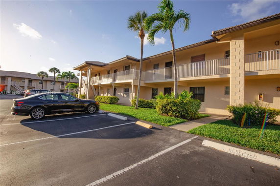 Outdoor parking area in front of a two-story apartment building.