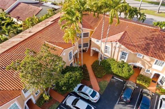 Aerial view of a complex with orange-tiled roofs and a central courtyard entrance.