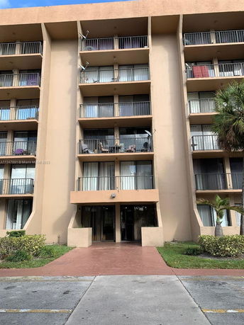 Front view of a multi-story apartment building with balconies.