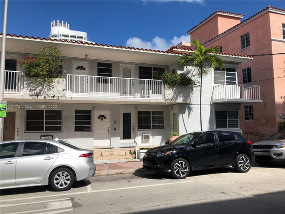 Front view of a two-story building with balconies and a flat roof.