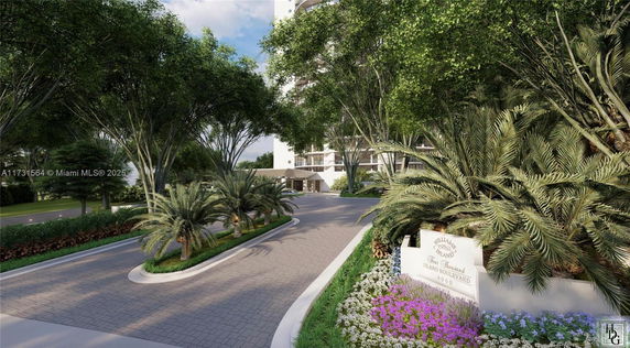 Entrance view of a modern apartment building with landscaped driveway.