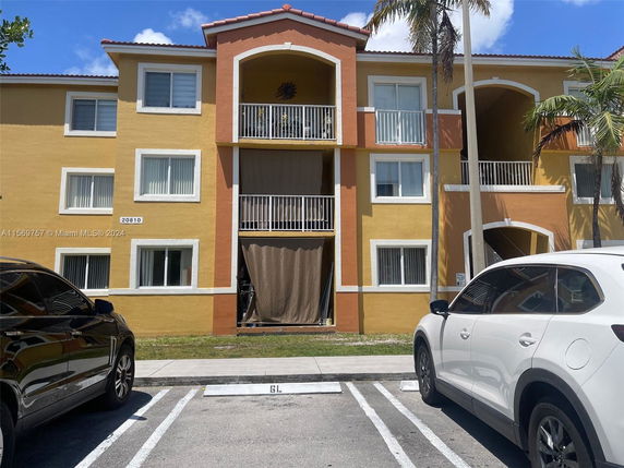 Front view of a three-story apartment building with balconies.