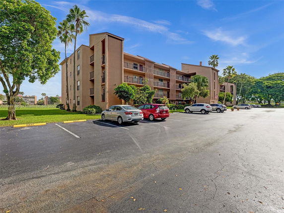 Four-story apartment building with a front parking lot