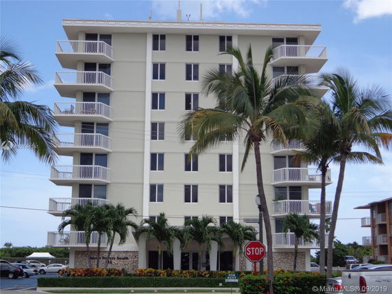 Front view of a multi-story apartment building with balconies.