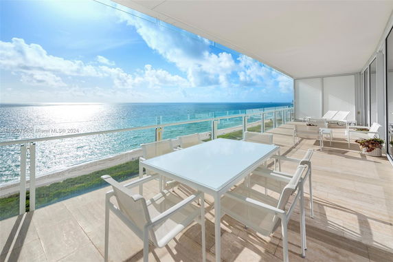 Outdoor balcony with seating and ocean view.
