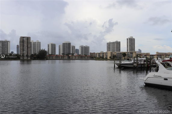 Wide view of waterfront buildings with boats docked in the foreground.