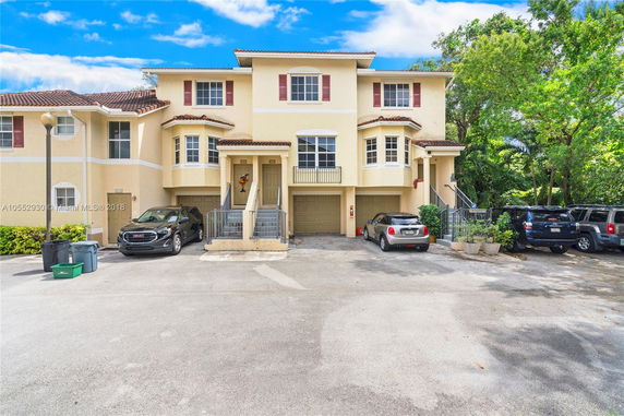 Front view of a multi-story townhouse with attached garages.