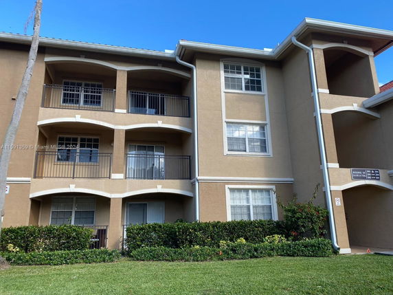 Front view of a multi-story apartment building with balconies.