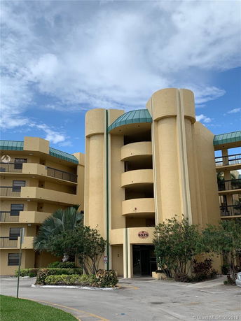 Front view of a multi-story building with curved balconies and a central entrance.