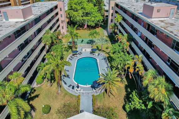 Aerial view of a central swimming pool surrounded by multi-story buildings with balconies.