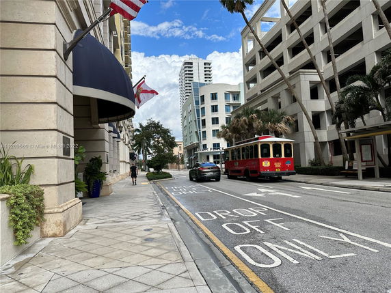 Street view with buildings and a drop-off area.