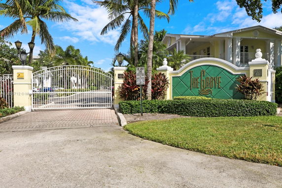 Front view of a gated entrance to 'The Grove' with a large sign and landscaping.