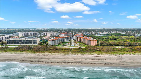 Panoramic view of a coastal cityscape with multiple buildings and beachfront.