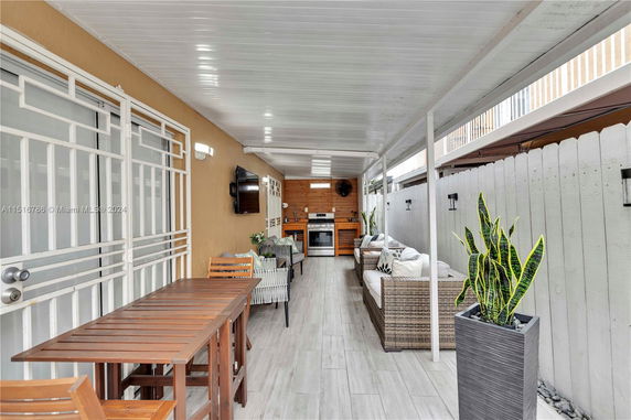 Covered outdoor patio area with seating and dining furniture.