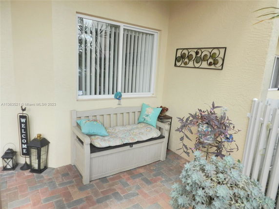 Outdoor seating area with a bench and decorative plants.