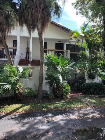 Front view of a house with a small balcony and tiled roof.