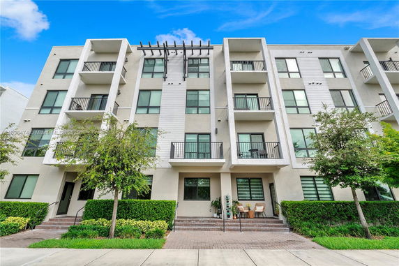 Front view of a four-story apartment building with balconies.
