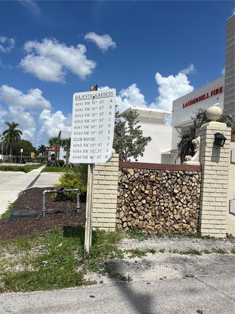 Front view of a building with a signboard detailing 'Majestic Gardens' and various addresses.