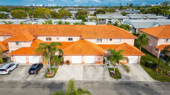 Front view of a two-story house with orange roof tiles and double garages.
