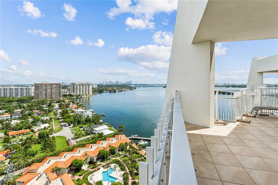 Panoramic view from a high-rise building showing a waterfront and surrounding cityscape.
