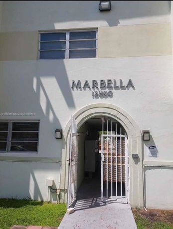 Front view of a building with gated entrance and the name 'Marbella' written above.