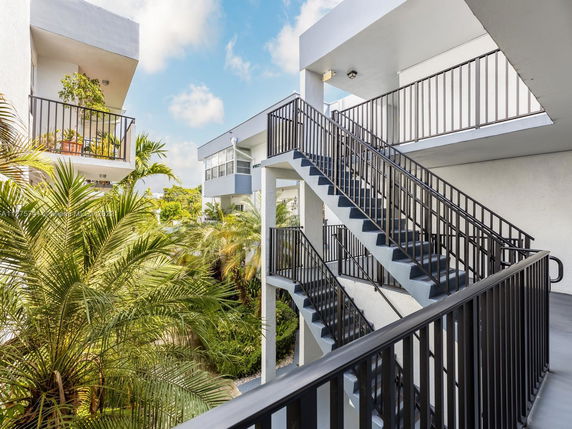View from an outdoor stairway with modern railings and surrounding greenery.