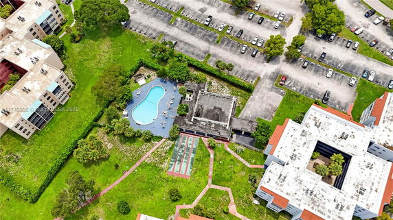 Aerial view of a residential complex with a swimming pool and parking lot.