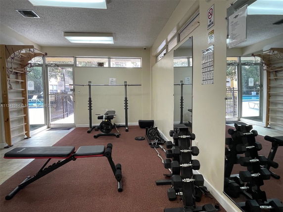 Indoor gym area with exercise equipment and mirrors.