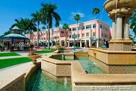 Front view of a multi-story building with pink facade and fountains in front.