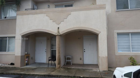 Front view of a building facade with two entrance doors and archway.