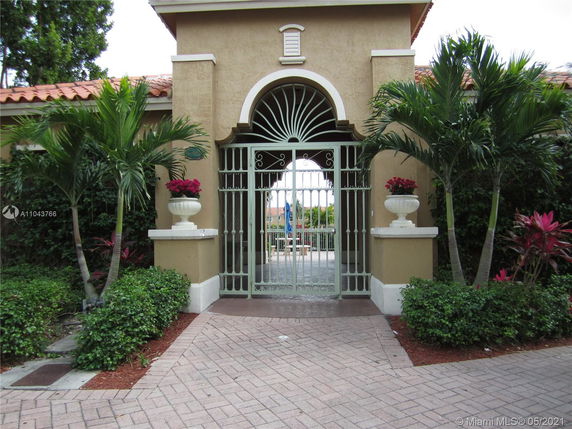 Front view of a building entrance with decorative gate and plants.