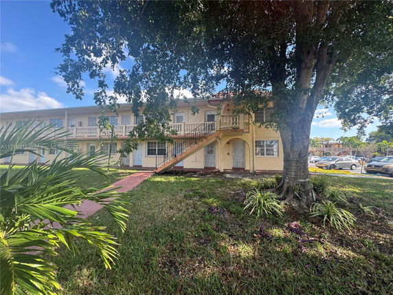 Front view of a two-story residential building with an exterior staircase.