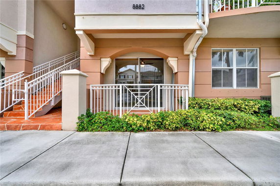 Front view of a building entrance with stairs and railing.