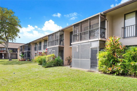 Front view of a two-story residential building with screened balconies.
