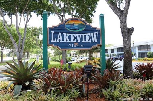 Image of a sign reading 'Lakeview at Hammocks' with nearby buildings and trees.