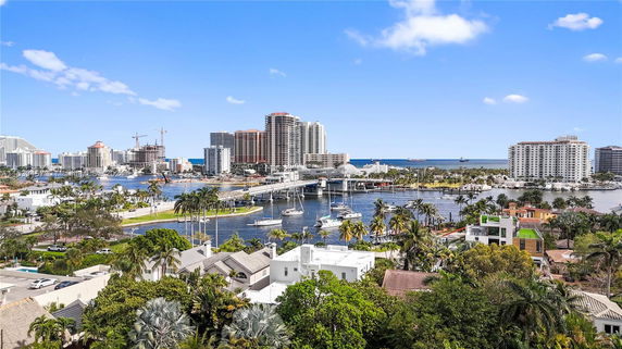 Panoramic view of a coastal city with buildings and a marina.