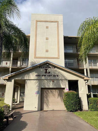 Front view of a multi-story building with balconies and a garage entrance.