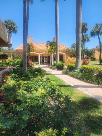 Front view of a house with orange roof tiles and arched entrances.