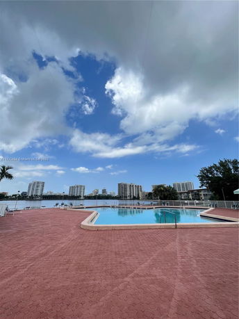 Outdoor swimming pool with city skyline in the background.