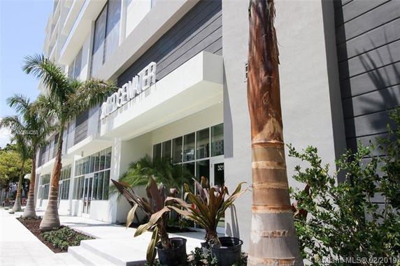 Front view of a modern multi-story building with large windows.