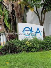 Signage with the text 'OLA' in a landscaped area.