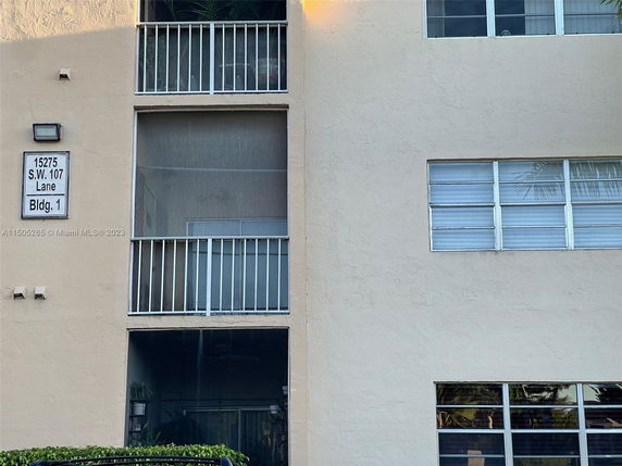 Front view of a multi-story building with balconies and windows.
