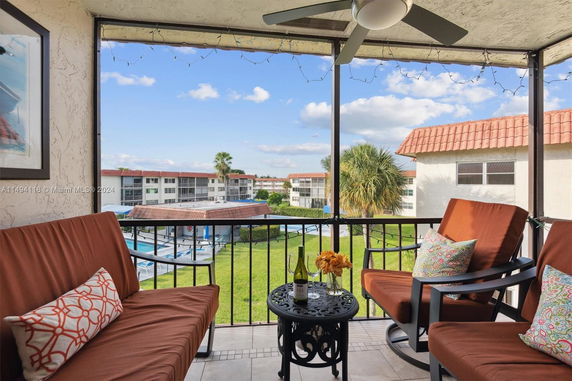 Patio view overlooking a residential complex with multiple buildings and a lawn area.