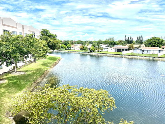 View of a river with buildings and trees alongside.